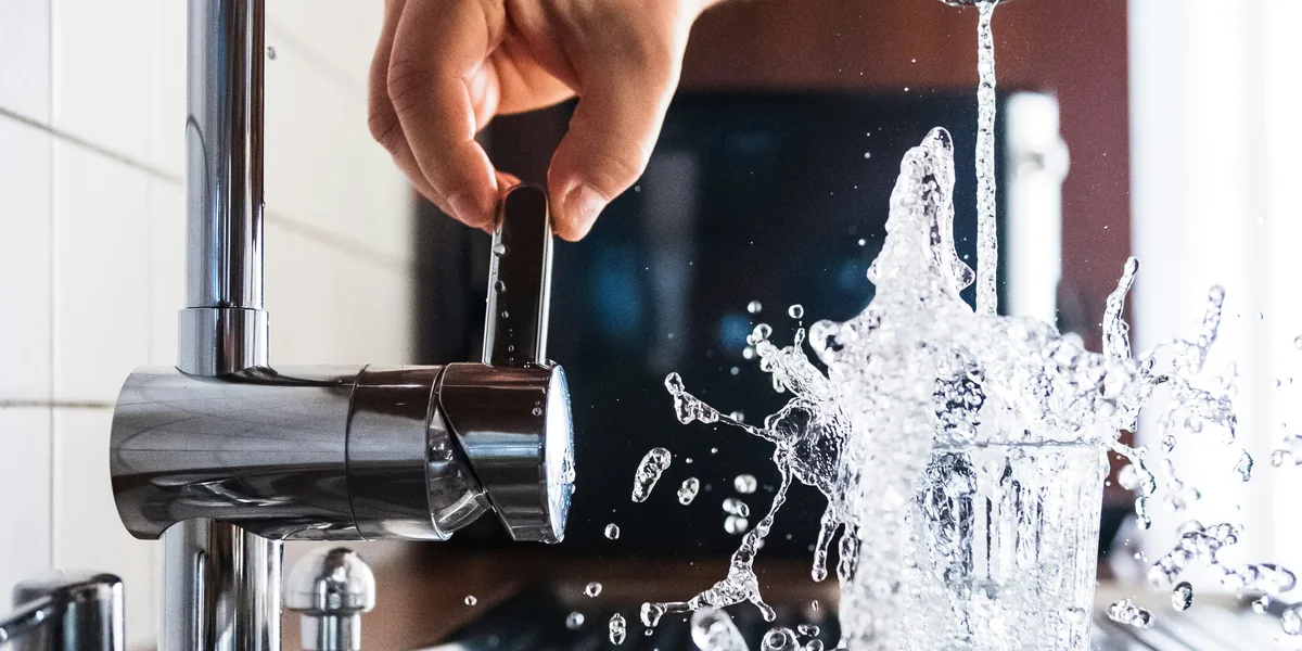 Grifo de cocina llenando un vaso de agua